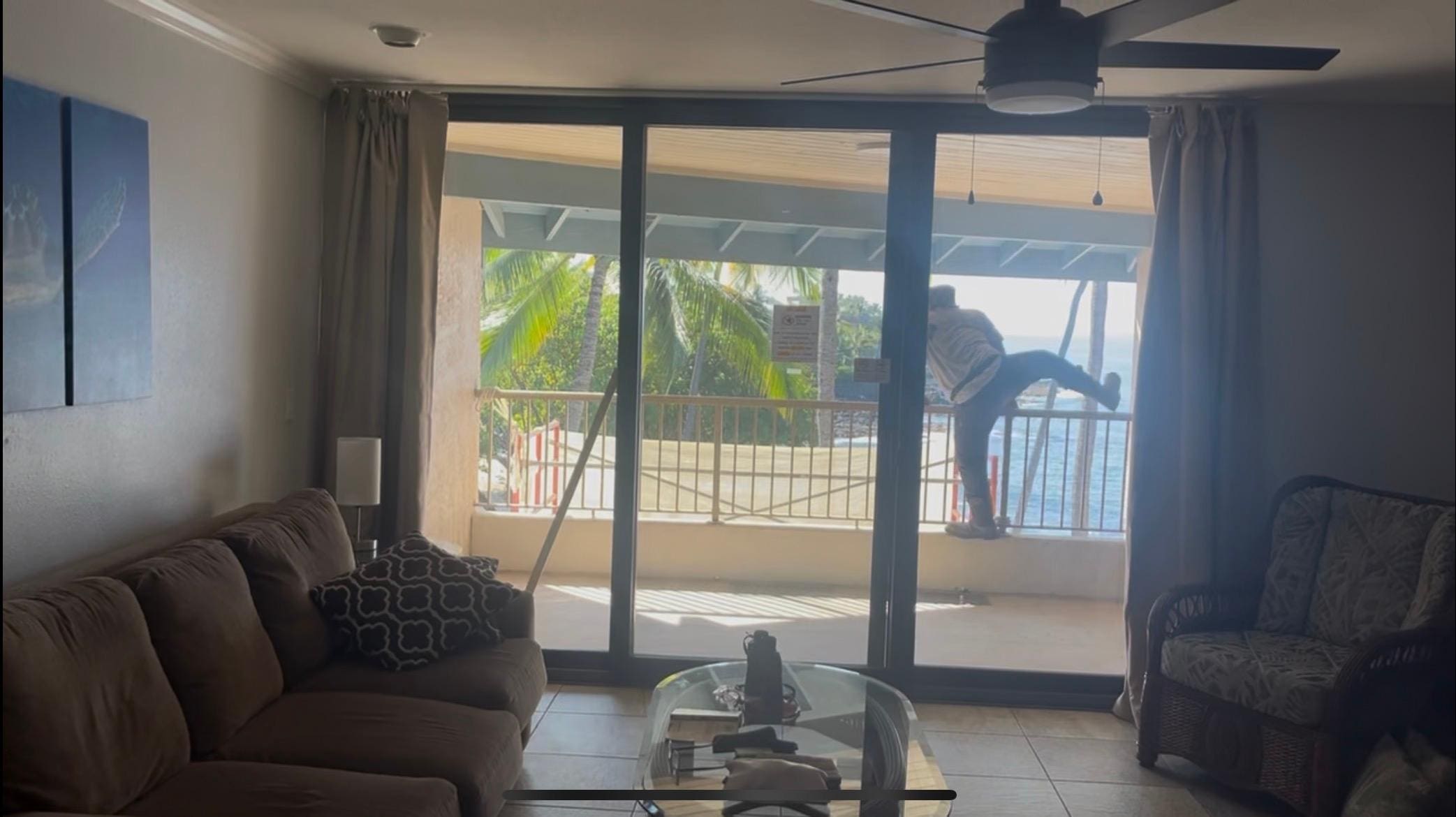 Construction worker climbing over balcony onto scaffolding.  