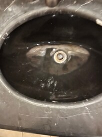 Dirty sink with toothpaste residue from prior guests