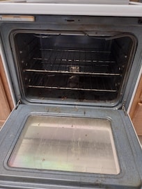 Filthy stove had a dead cockroach