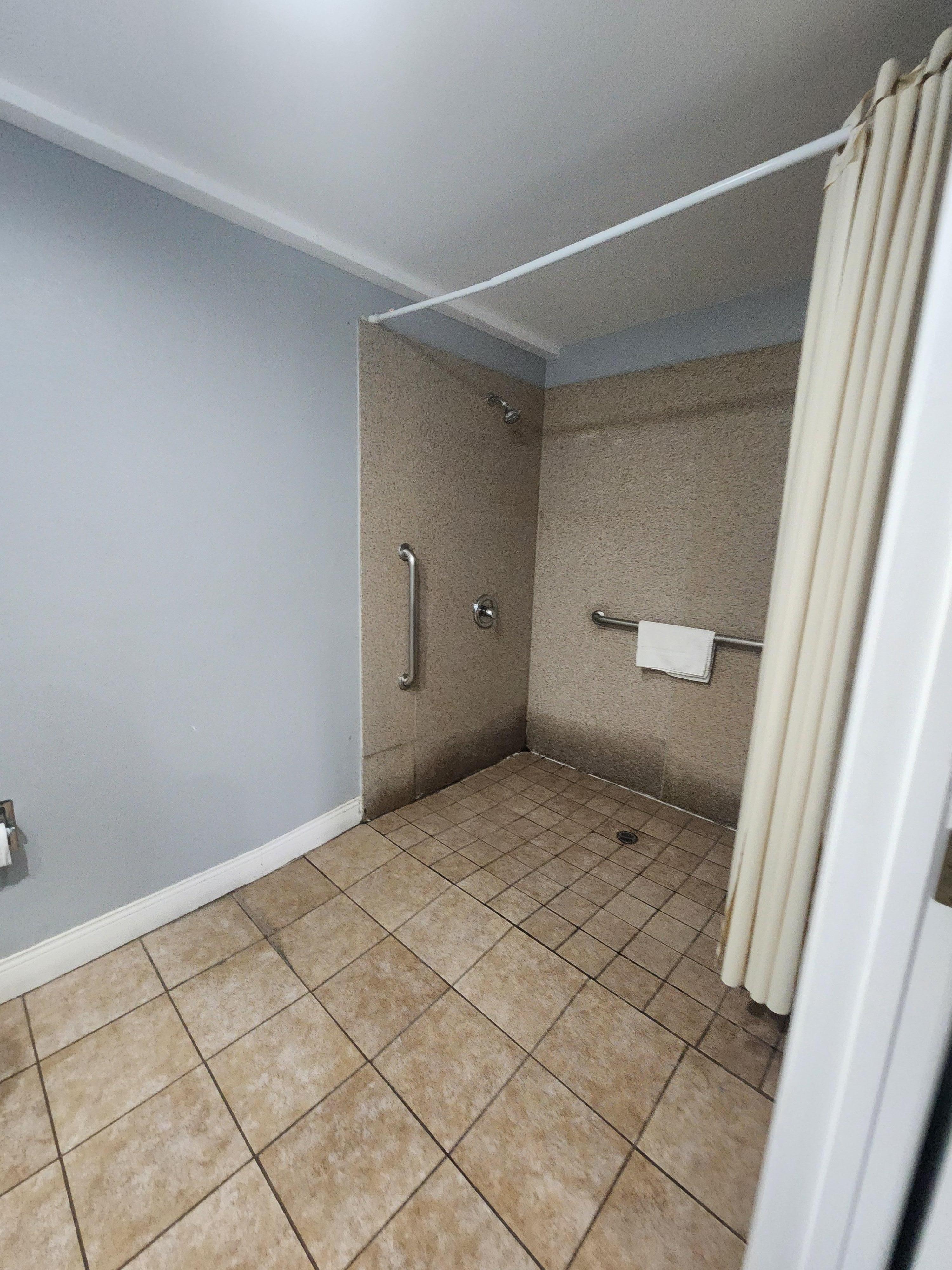 The shower might have been ADA but even then it's not safe because of slipping issues and water clogging while showering 