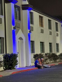 People hanging outside doors drinking and smoking.