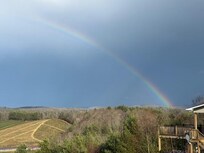rainbow over the Christmas tree farm in between thunderstorms