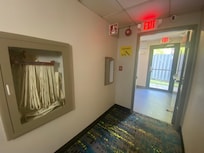 Inner fire door to 4-floor stairwell propped open (right); missing extinguisher (center); missing, broken-off handle to fire-hose glass door (far left, must smash glass)