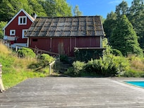 Blick von der riesigen Poolterrasse auf Haus und Schuppen
