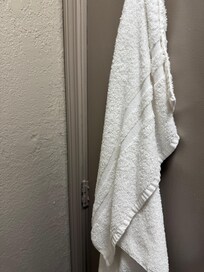 dirty towel behind bathroom door