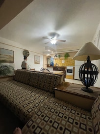 Spacious sitting room looking into kitchen. At night….its very bright with huge windows. Kitchen has all the basics.