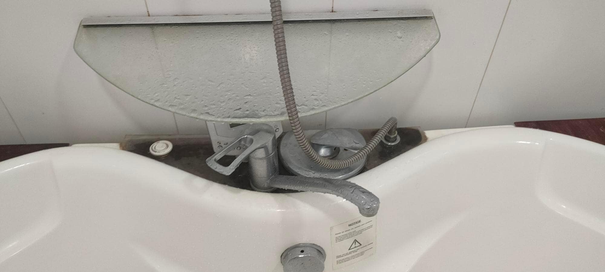 strange cover shielding the controls poorly from the shower above it