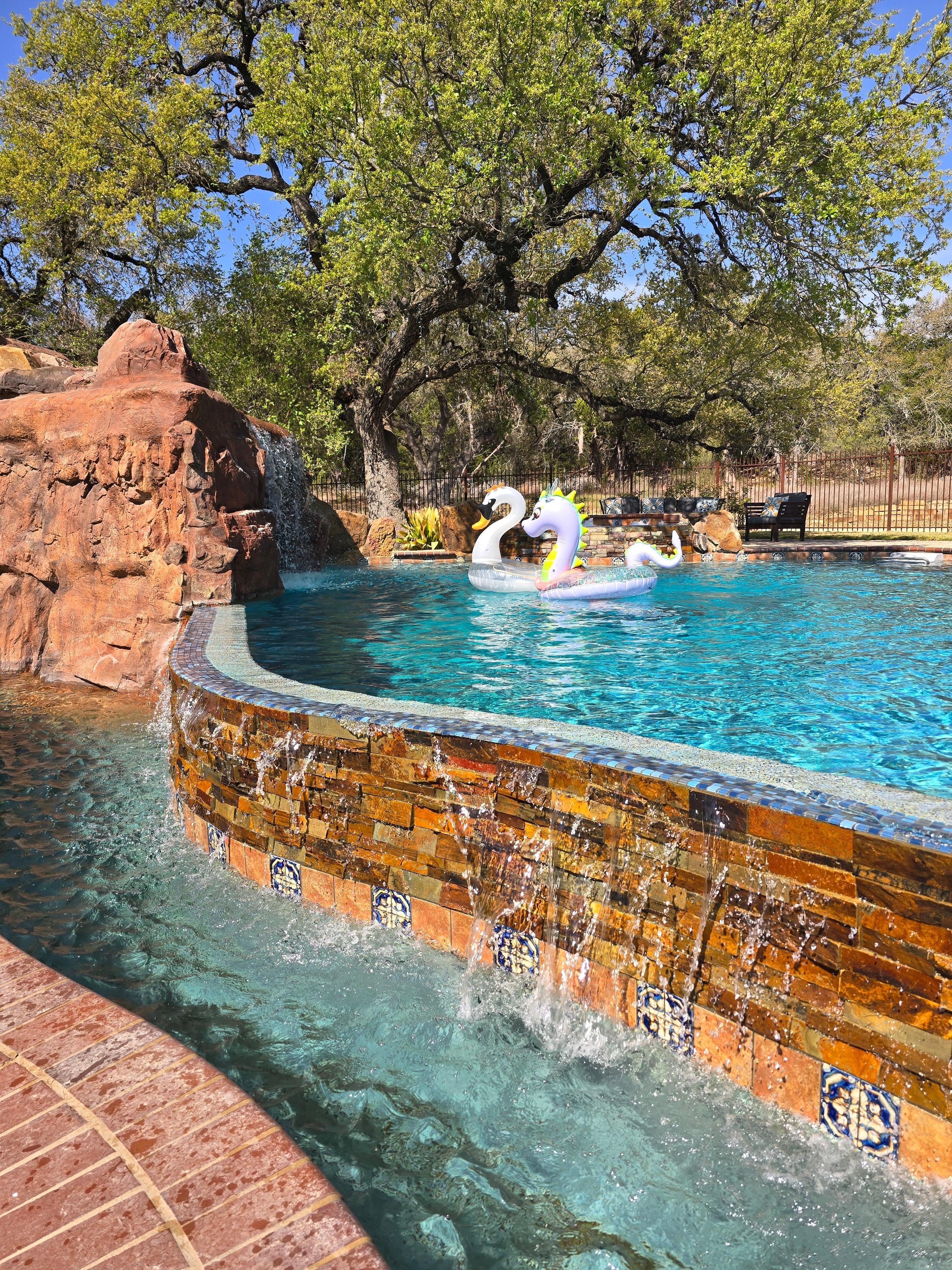 Pool has a waterfall infinity edge that's perfect for sitting/laying/hanging out.