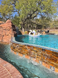 Pool has a waterfall infinity edge that's perfect for sitting/laying/hanging out.