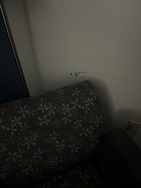 Paint scraped off wall by chair