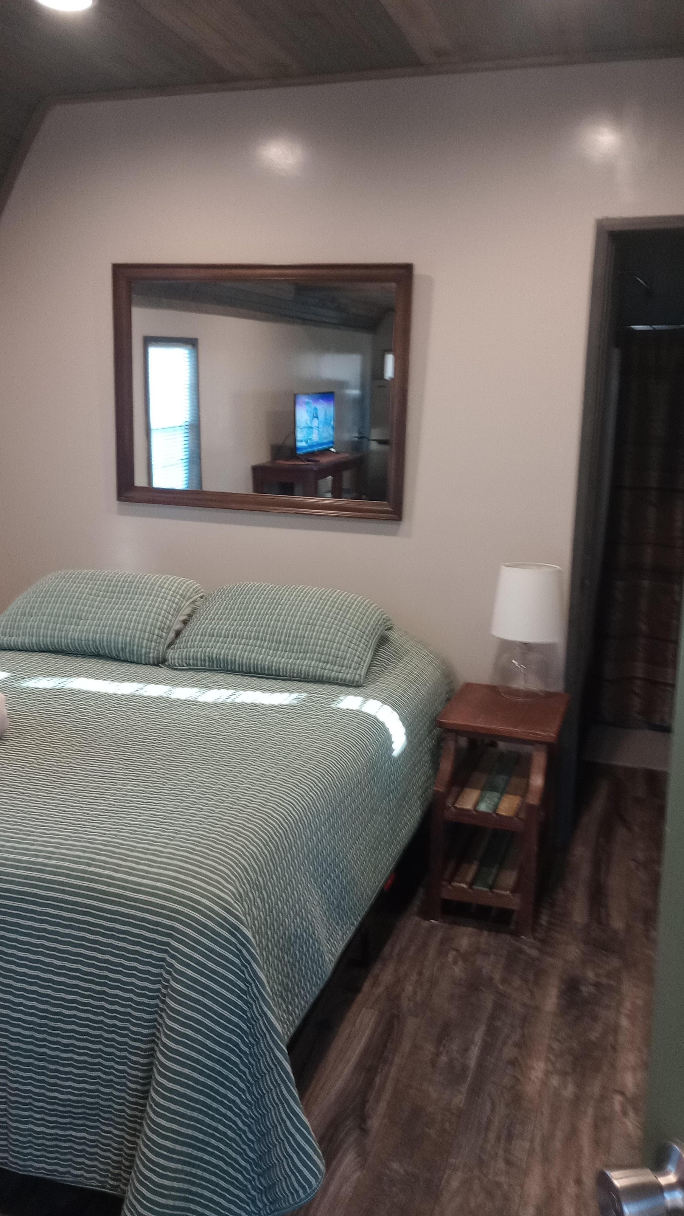 Warm queen bed, bathroom area beyond. 