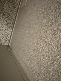 Urine on wall of toilet.
