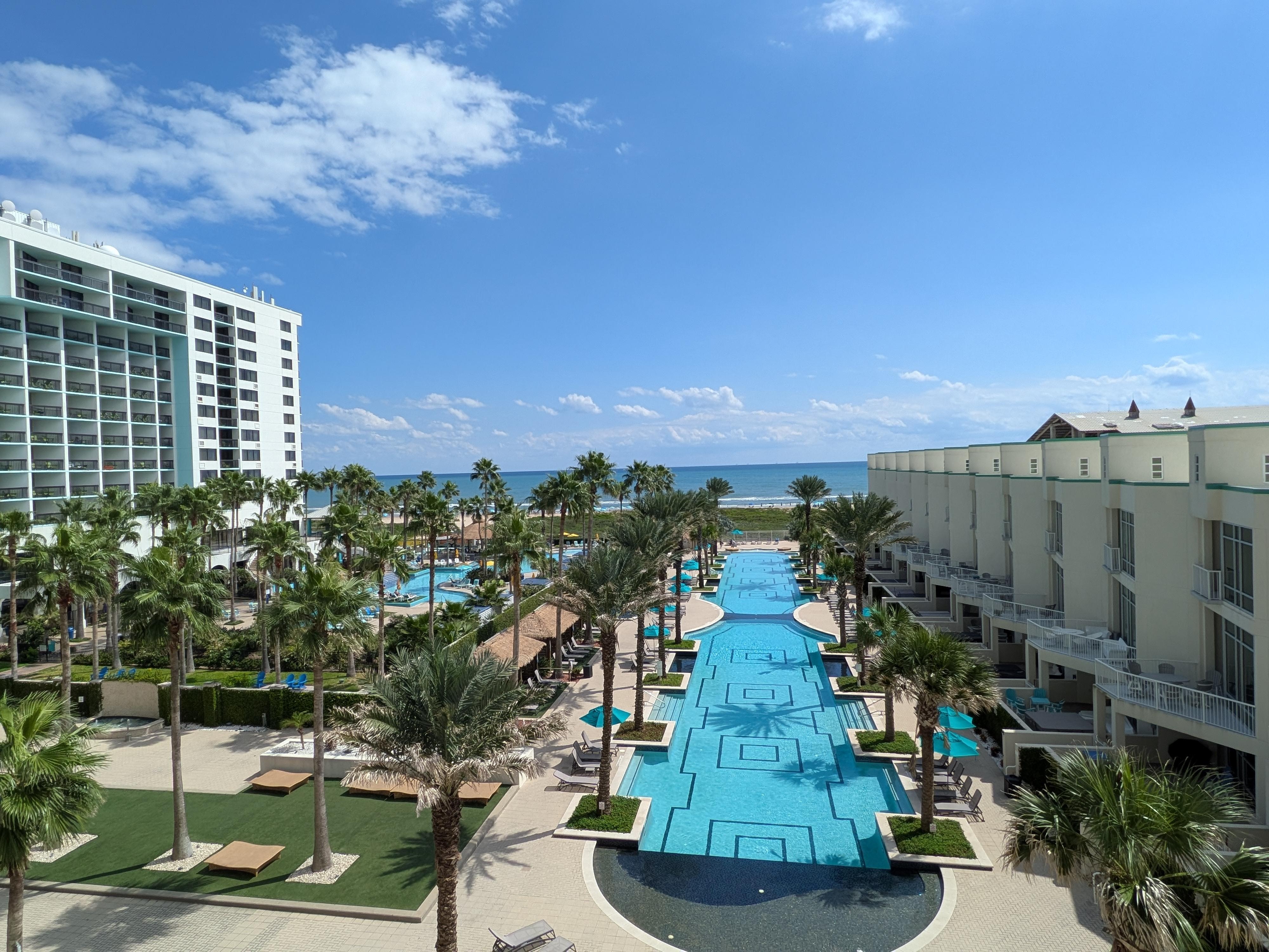 View from the 4th story Condo overlooking the resort/pool area with a view of the ocean.