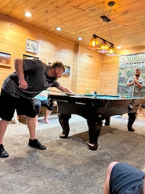 Guys enjoying the pool table