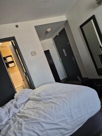 Folding bathroom doors to left. Entrance door far right with cabinet immediately behind it