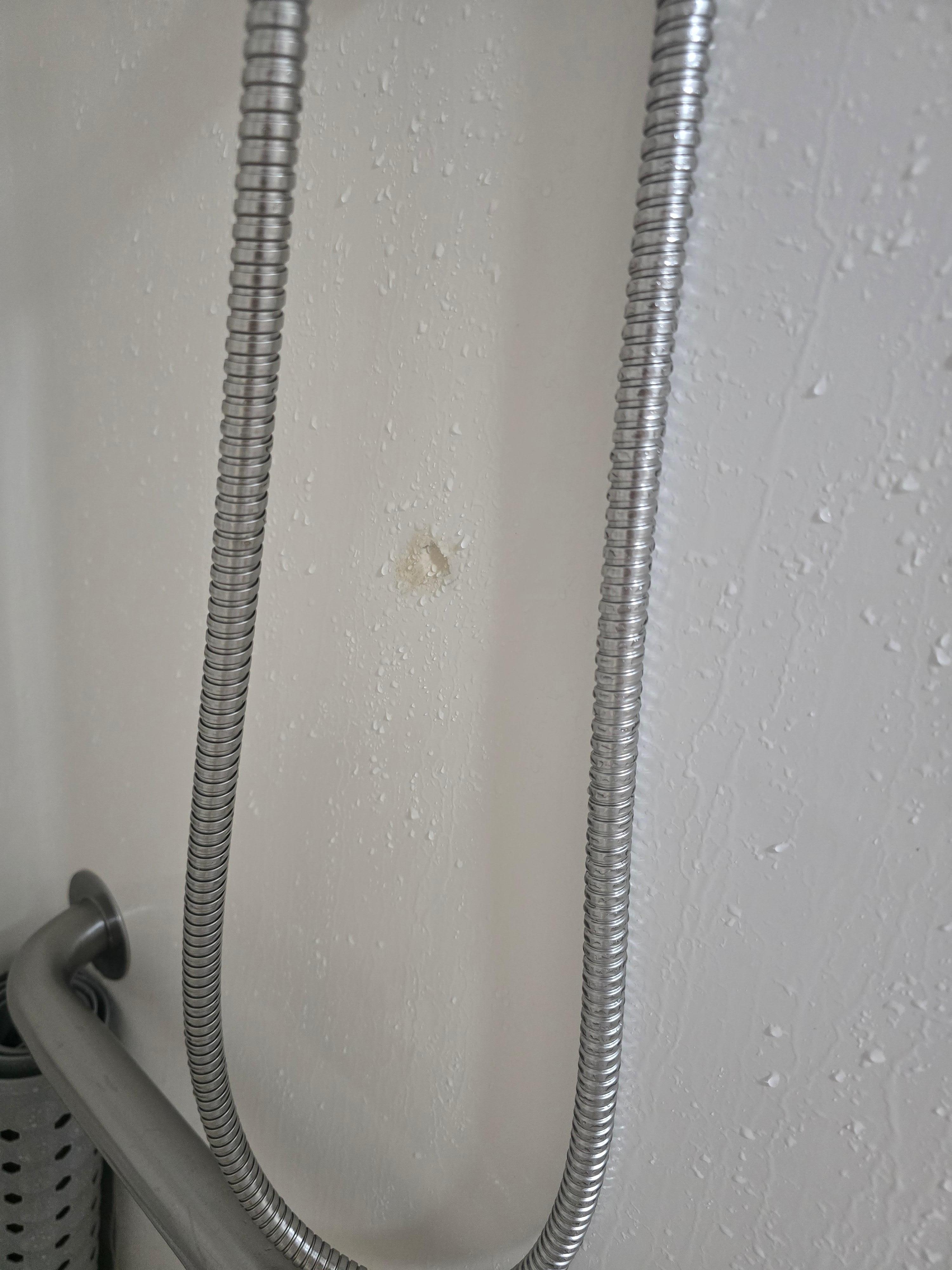 Shower wall poorly repaired. 