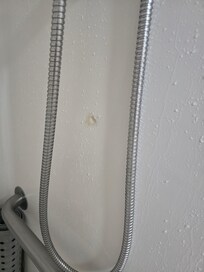 Shower wall poorly repaired.
