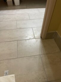 Tile floor between the bathroom and entryway