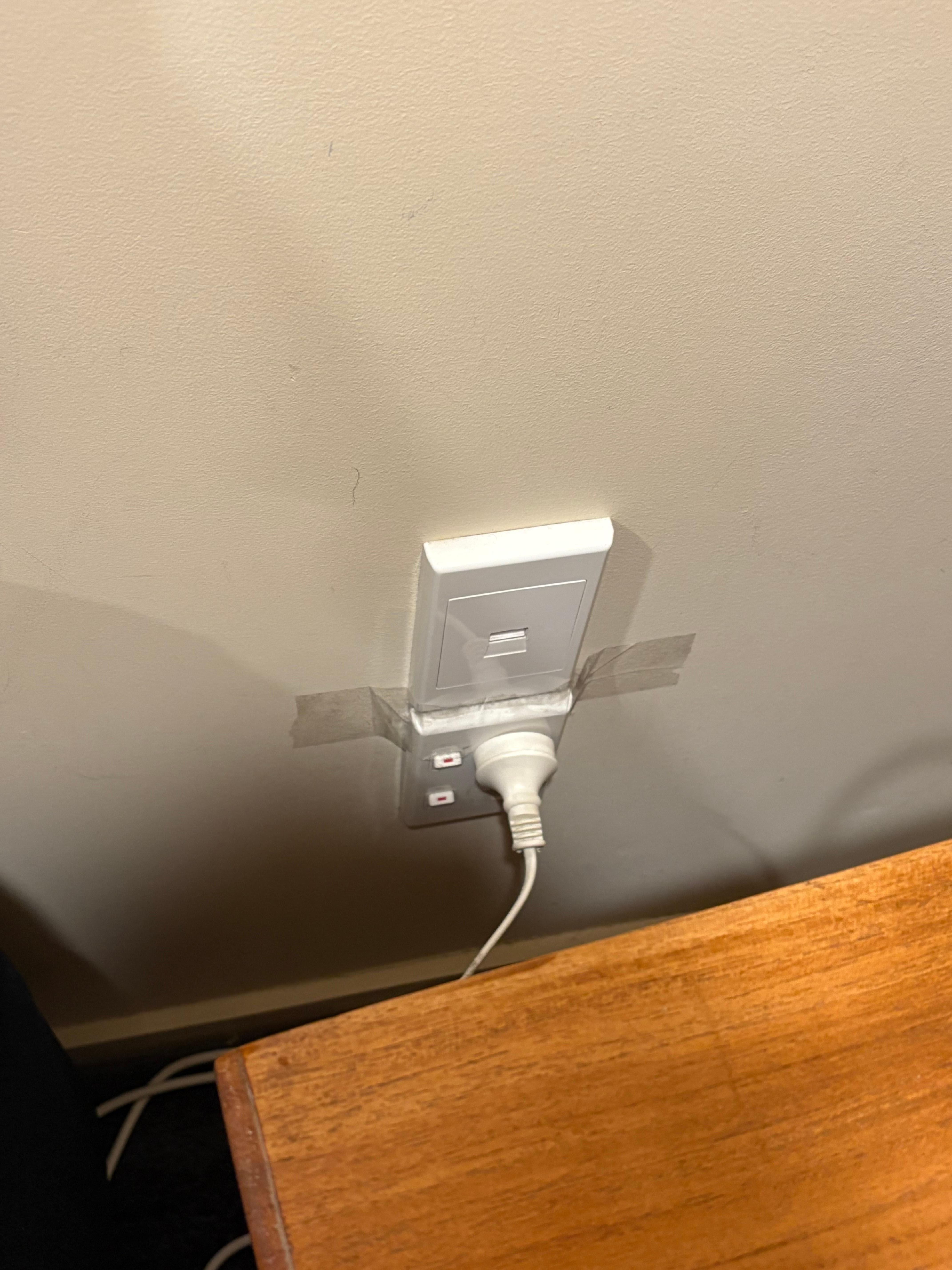 Outlet held on by packing tape. Not safe. 