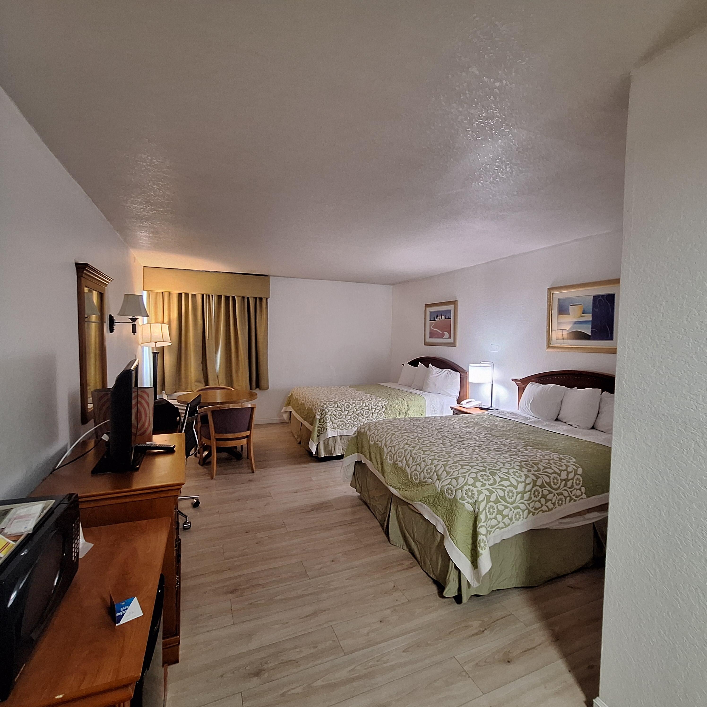 Clean room with decent space, a fridge, a microwave and a roomy bathtub with shower