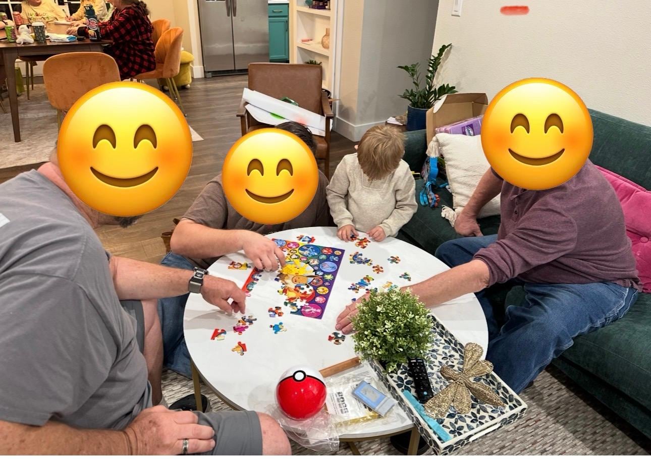 Four generations putting together a puzzle in the living room 