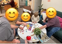 Four generations putting together a puzzle in the living room
