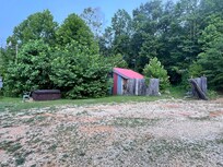 Garbage area with broken fences behind hot tub