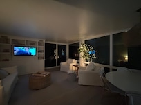 Large cozy living room area with wall of windows to porch