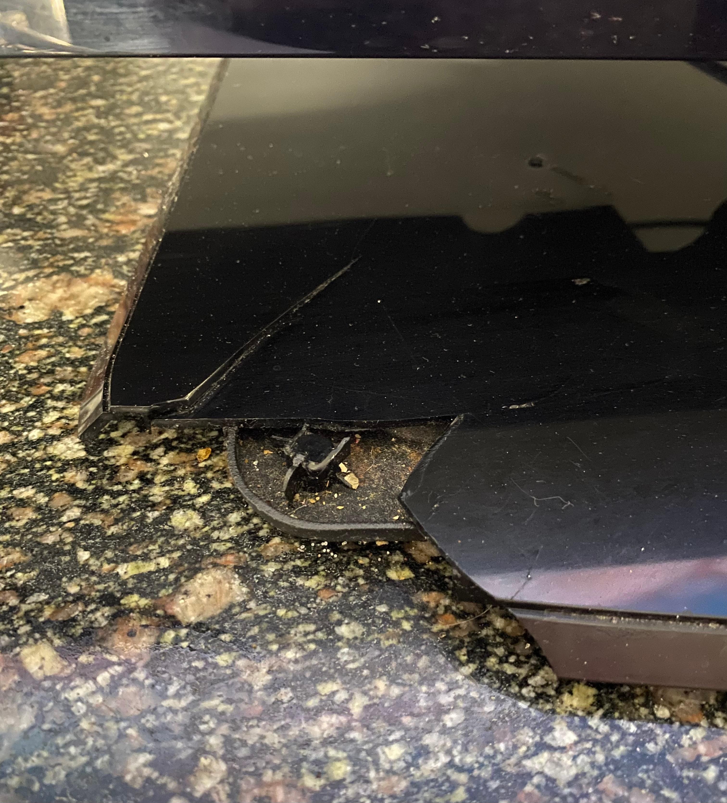 Tv stand broken with left over food crumbs under it.