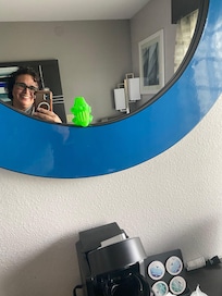 Desk and mirror in the room with coffee maker and coffee cups