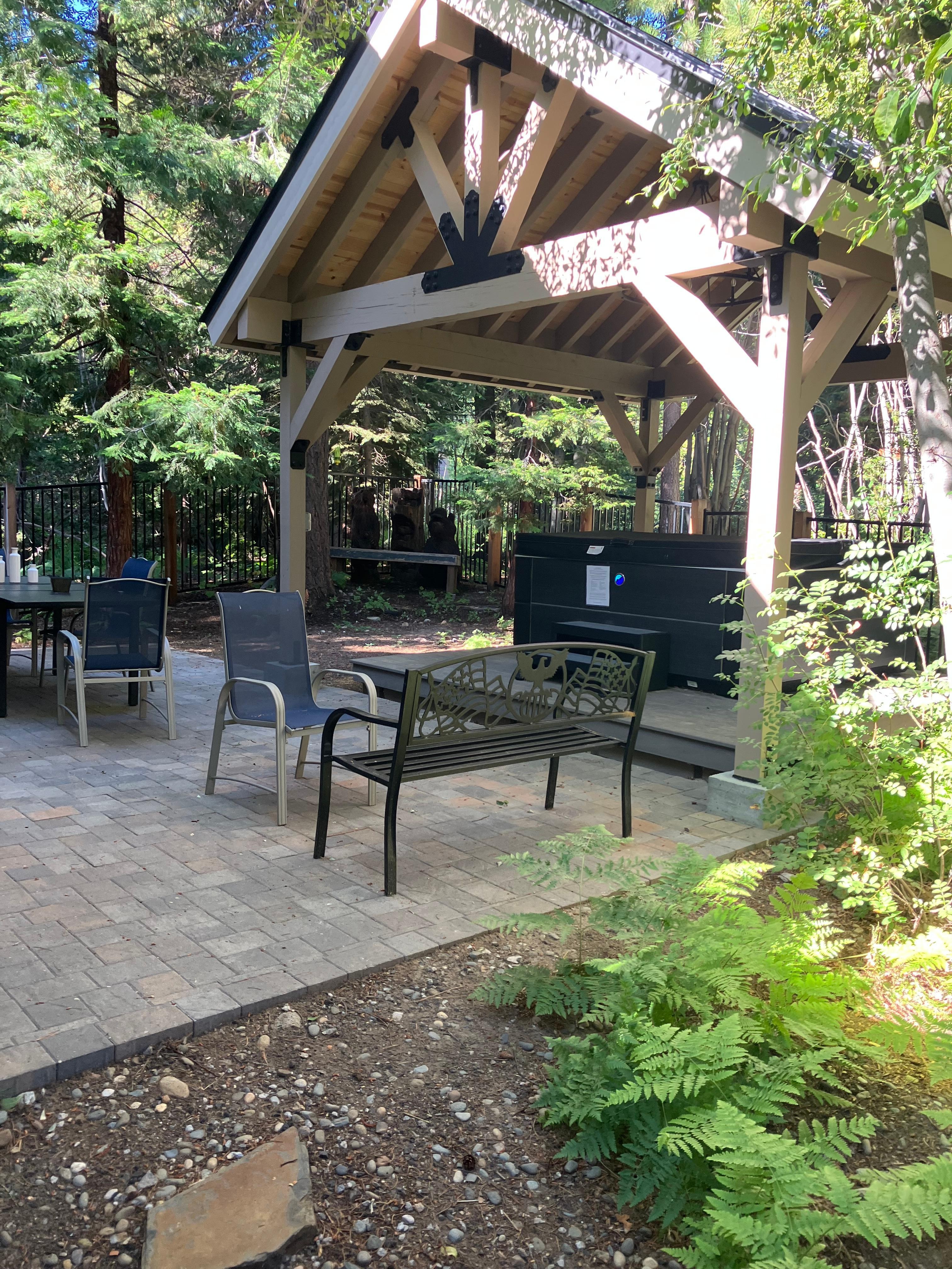 Fenced back patio is surrounded by forest