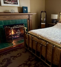 Comfy cozy bed next to a gas fireplace.