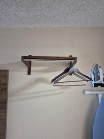 No closet, just this lopsided rack right next to bed