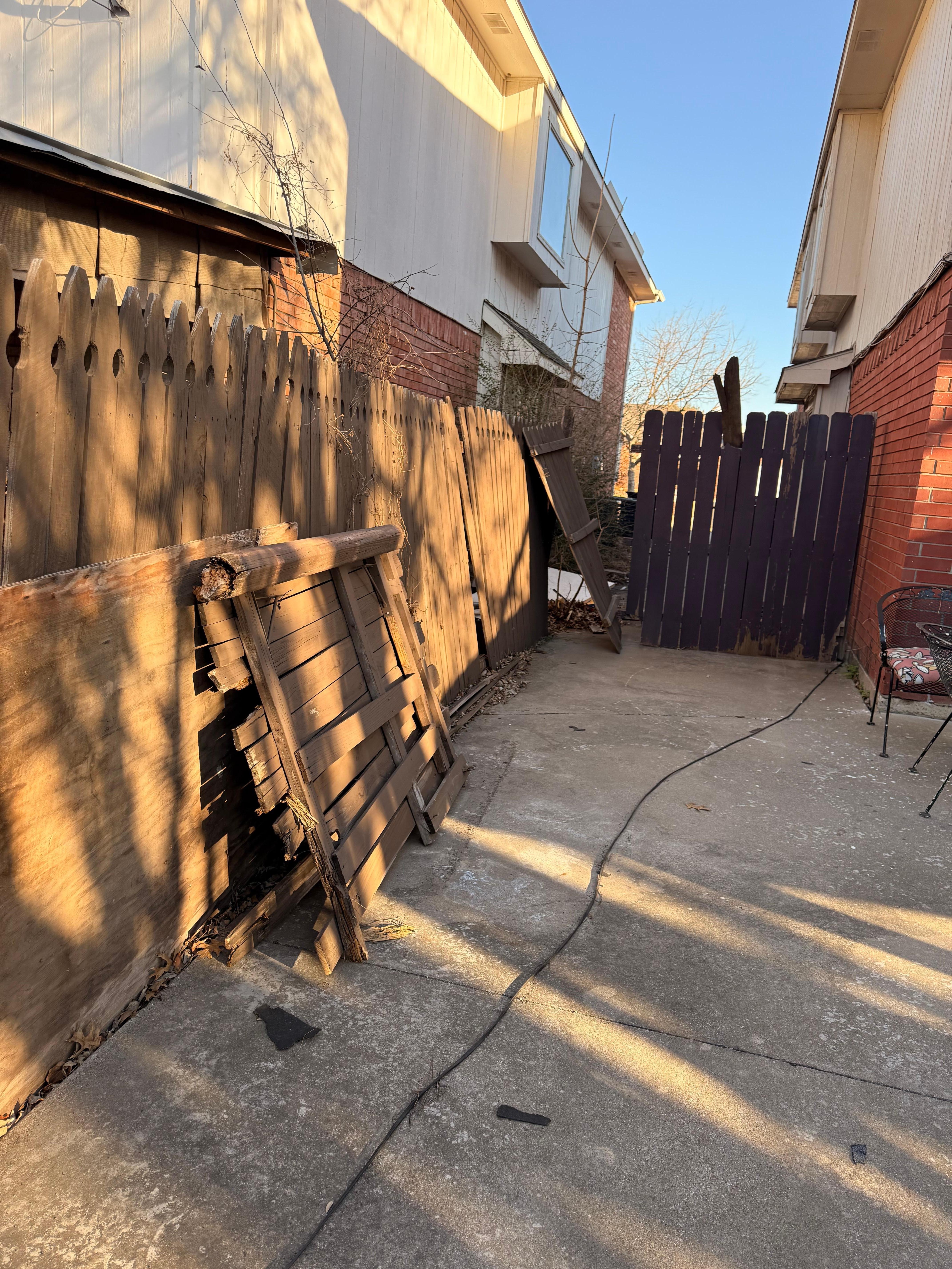 Broken fence laying in backyard 