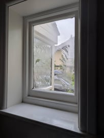 No curtains on this window next to the bed.