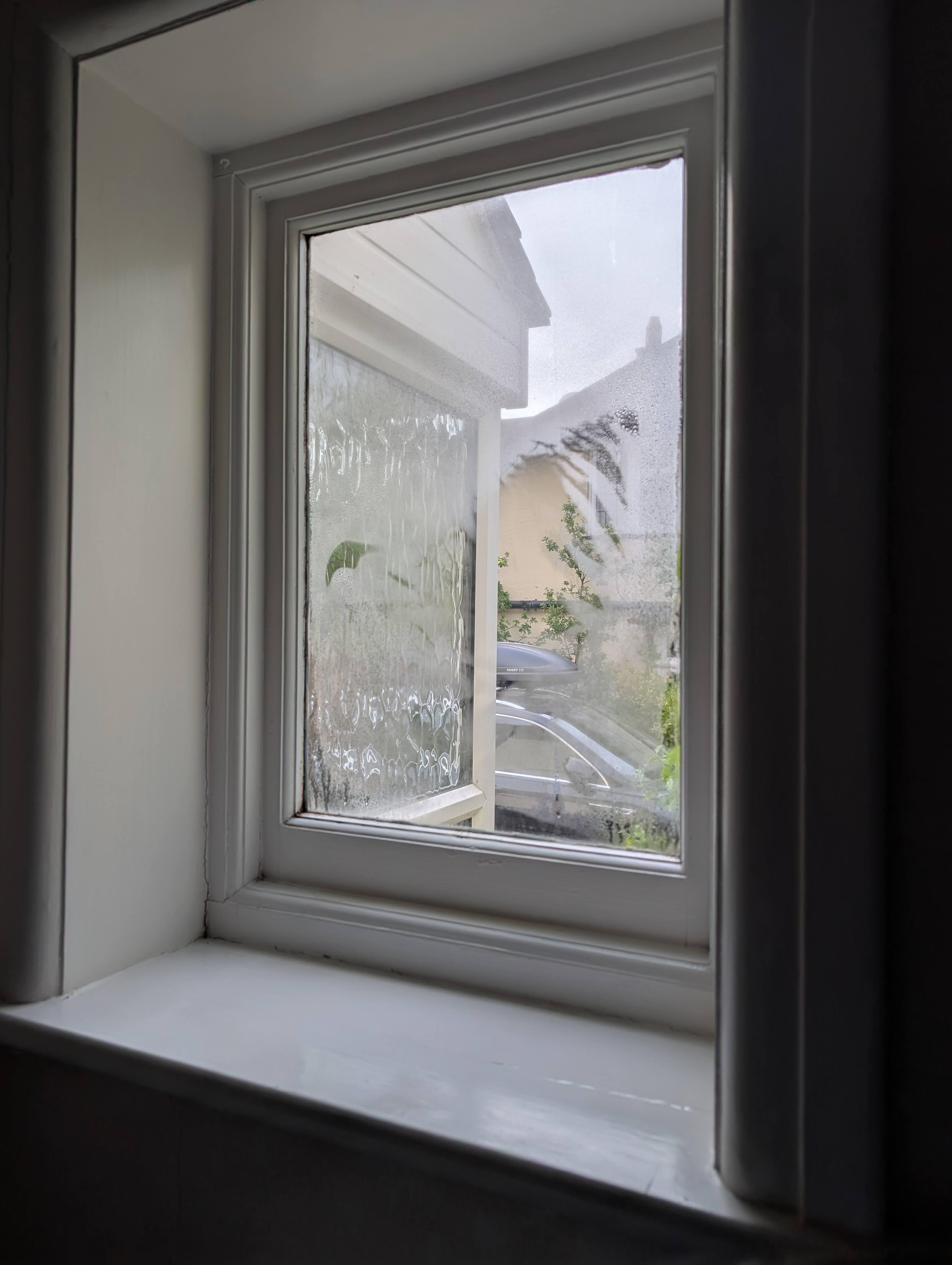 No curtains on this window next to the bed. 