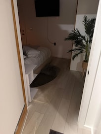 View of bedroom from laundry room. There is an exterior door here but no code or key is provided so you can’t use it for secure exit or entry.