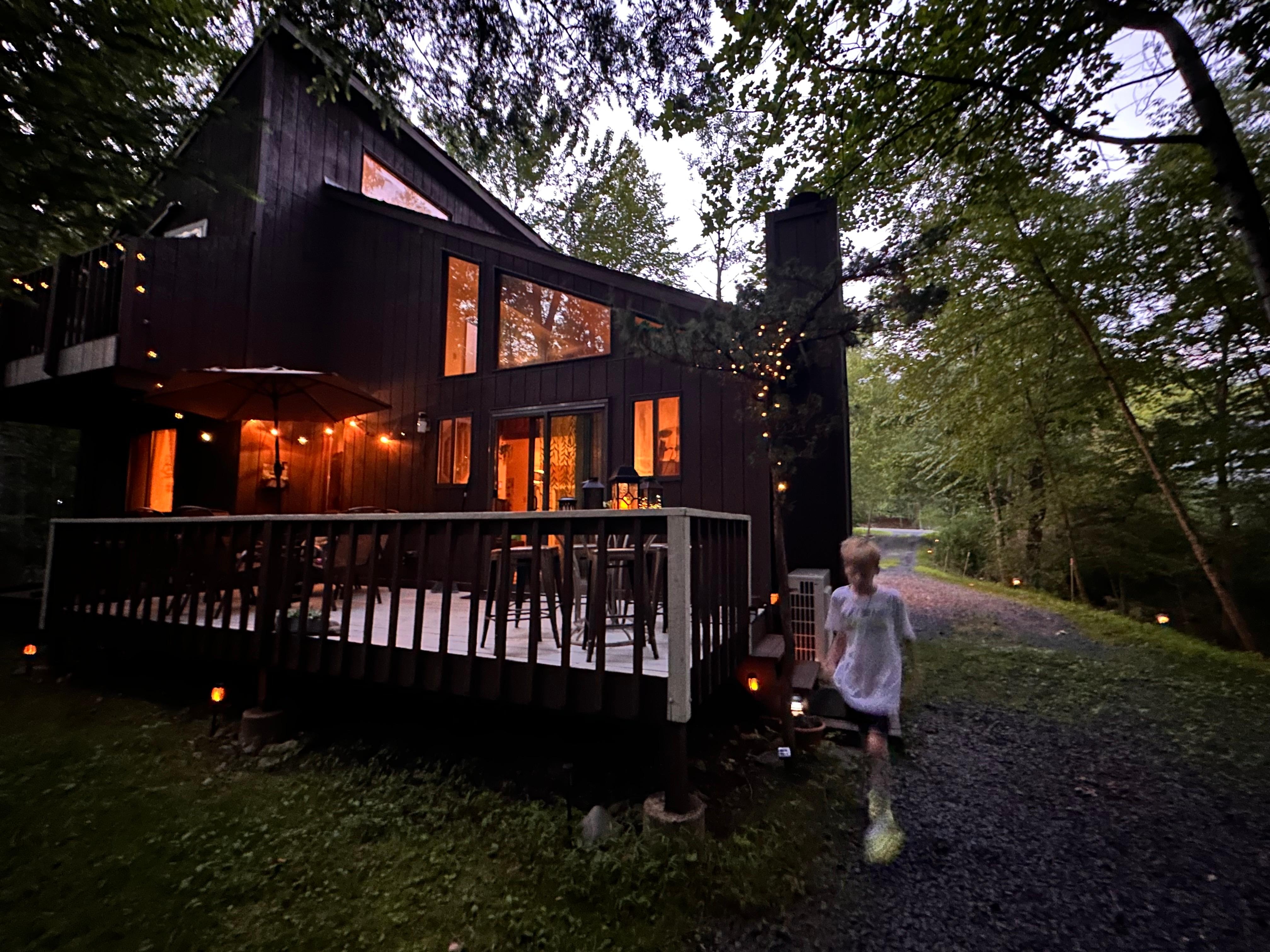 A picture of the house from the barbecue/fire pit area at night 