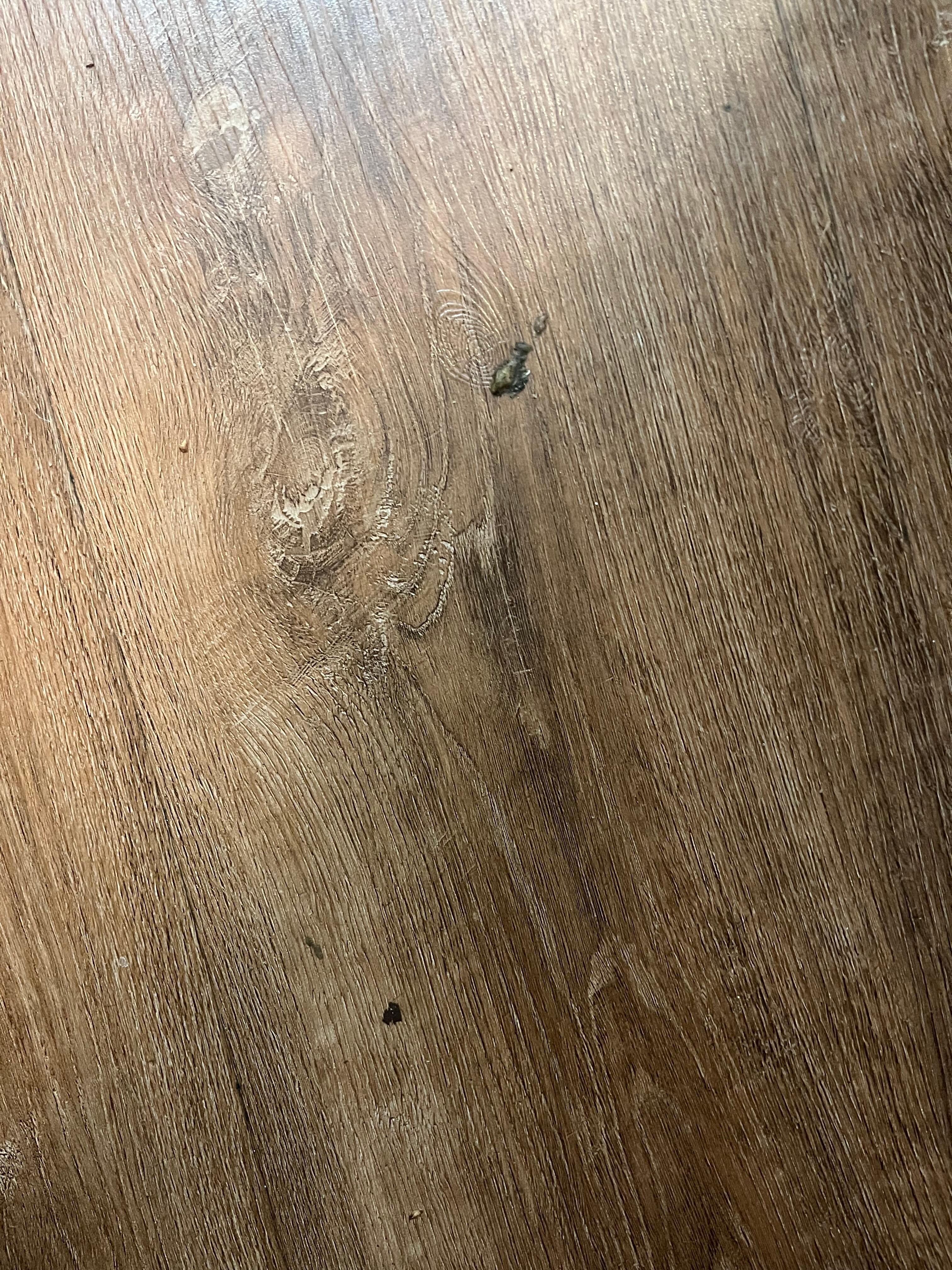 Black debris stuck to floor.