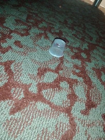 Childs medicine used cup under the bed with trash