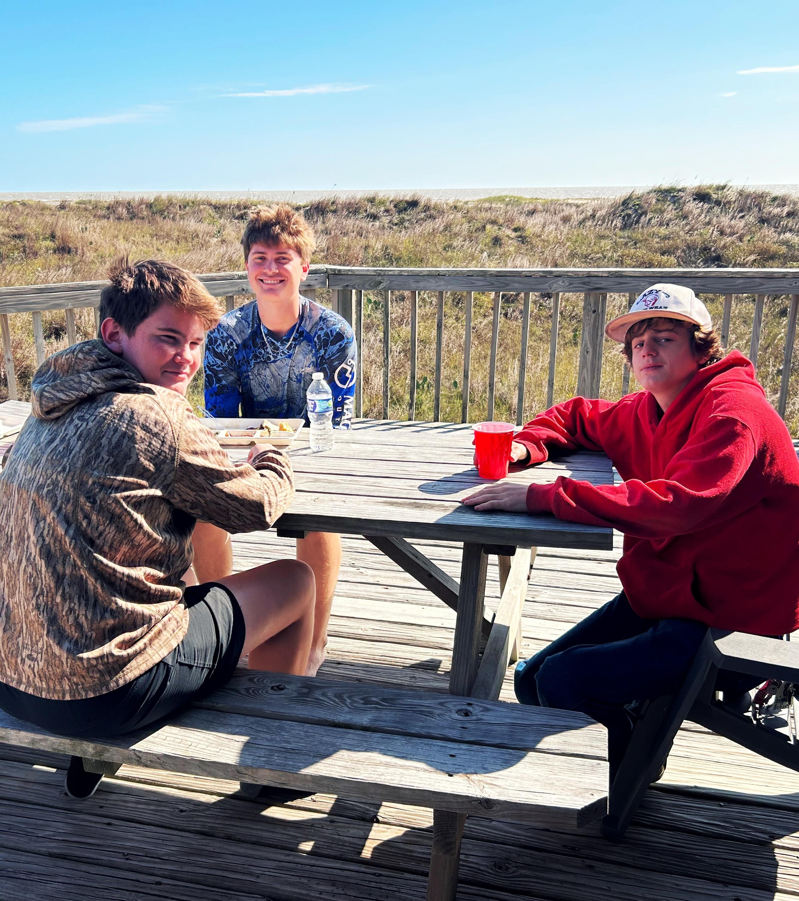 Grandsons enjoying the sunshine on the deck while eating