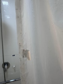Banheiro sem box e com cortina velha e cheia de mofo