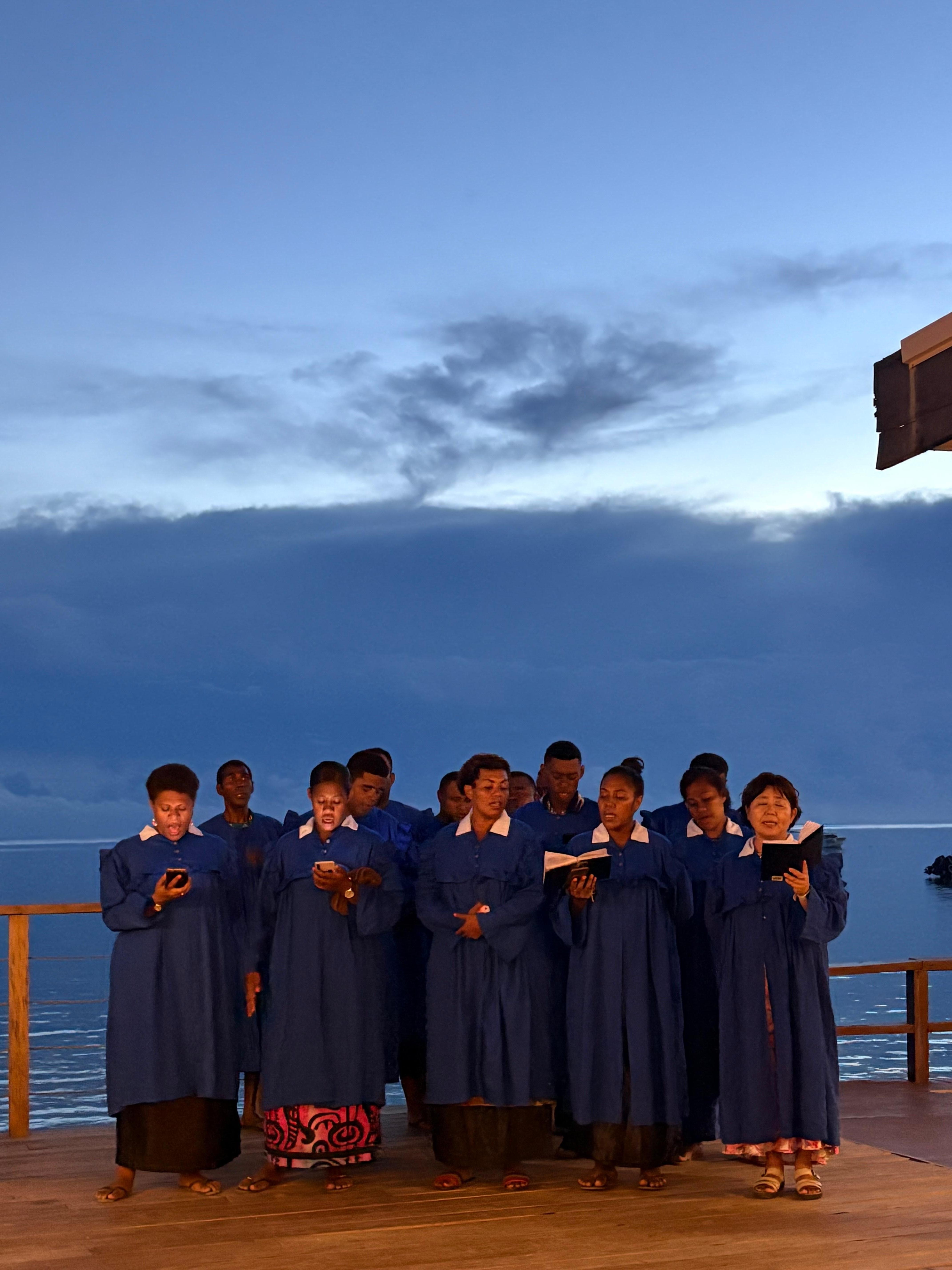 The choir singing hymns at sunset. 