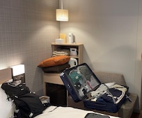 Une des valises sur la banquette pas d’armoire juste des accroches plaquées au mur