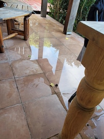 Water on patio due to leaking hose - this is the only way to the pool without walking around and through the grass.