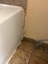 Between the tub and toilet in the bathroom