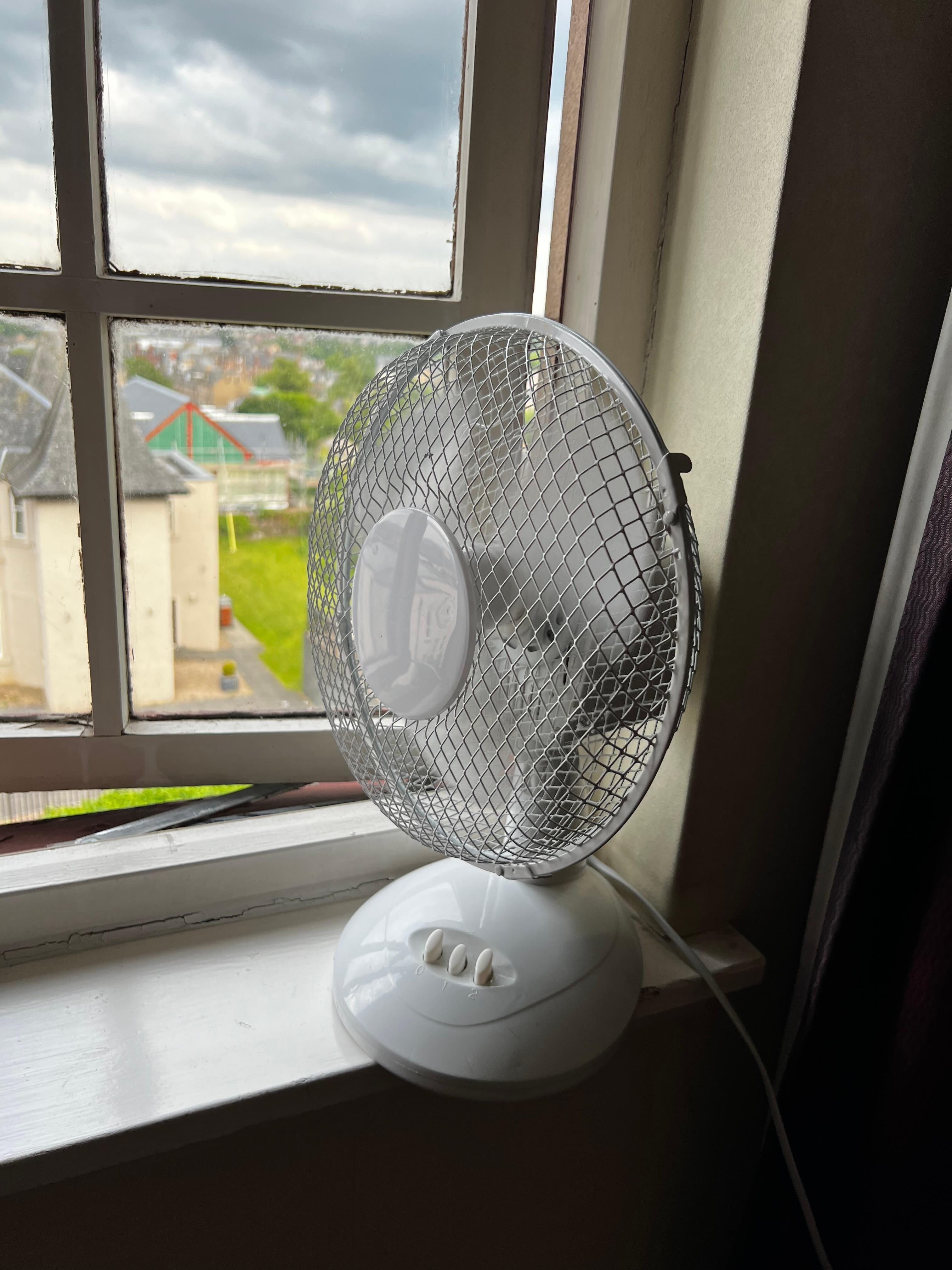 €10 noisy plastic fan “cooling” the room