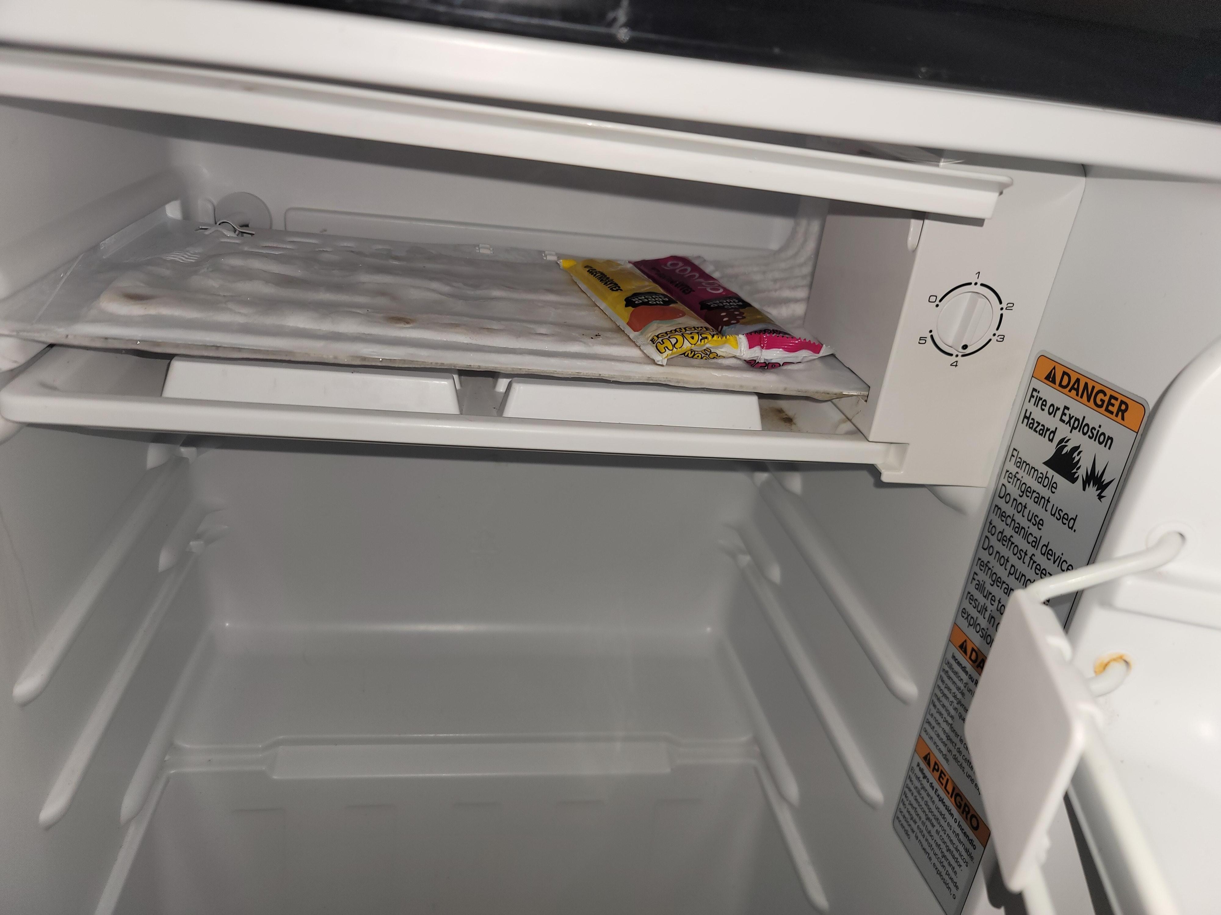 Moldy non working fridge with some type of yogurt that was left inside.