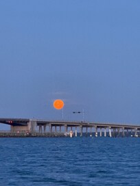 full moon, going down at 6am over the Dunedin Causeway