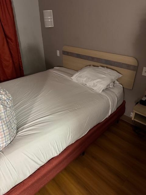 The bed and dirty head board and only pillows for one 